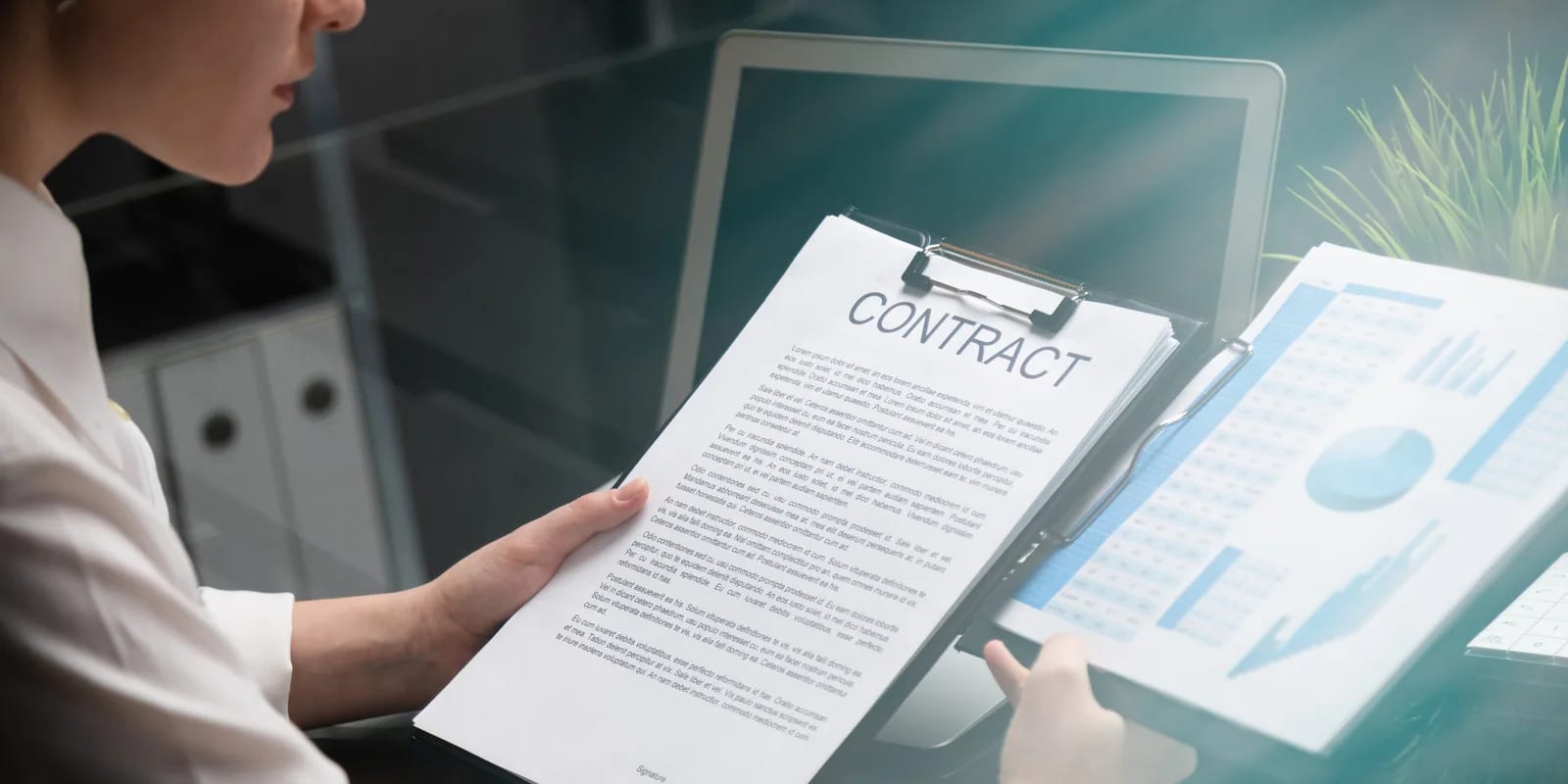 A lawyer reading a contract against an analysis on screen