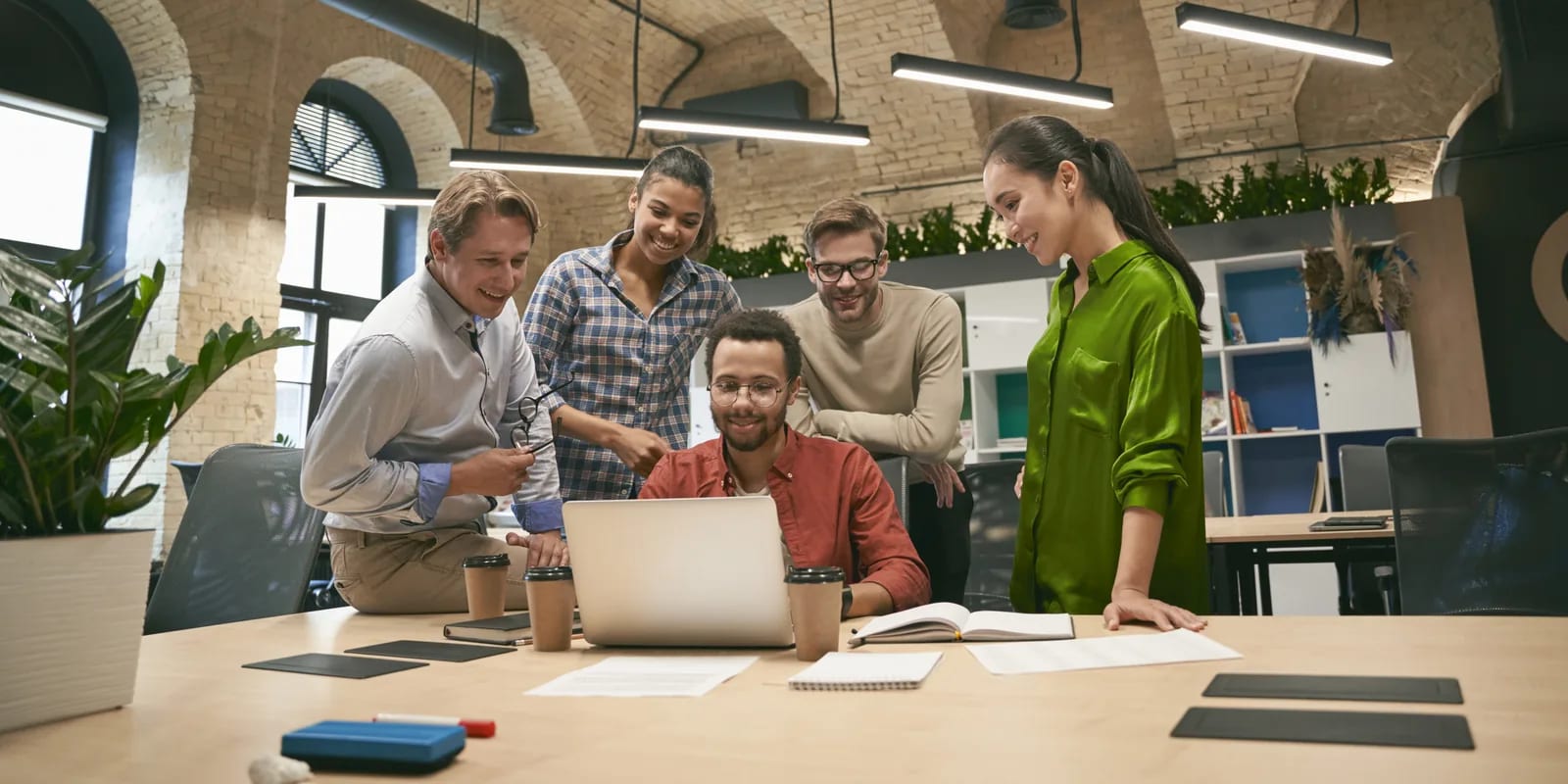 A team working through a problem together around one laptop