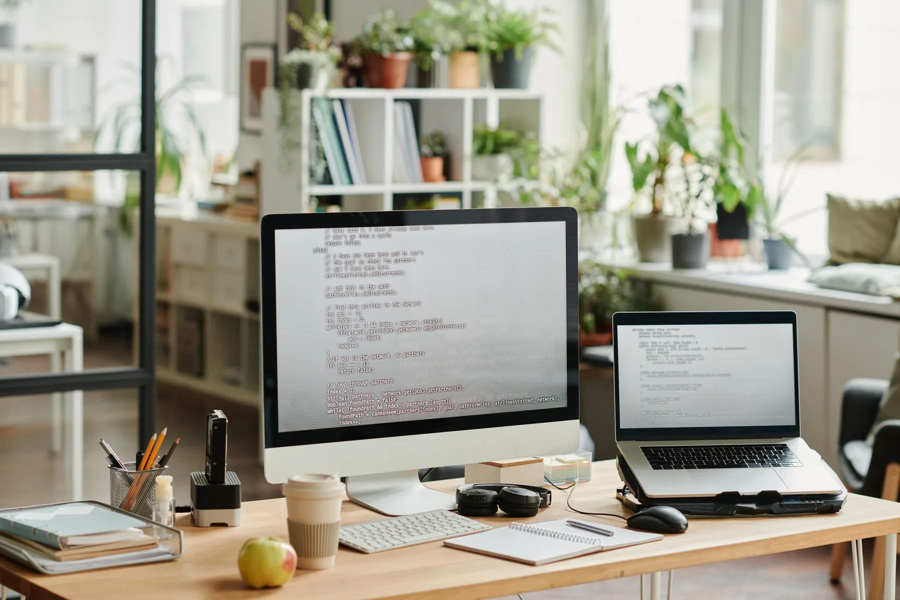 A writing desk with a desktop and a laptop open side by side