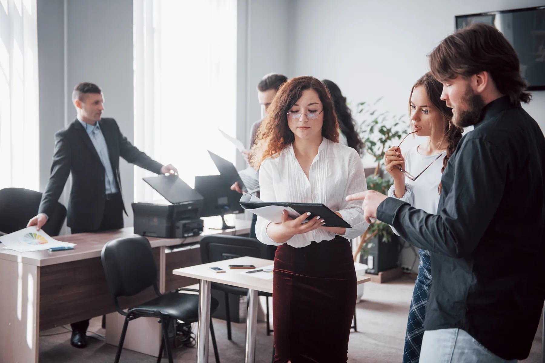 A colleague walking two others through an open document