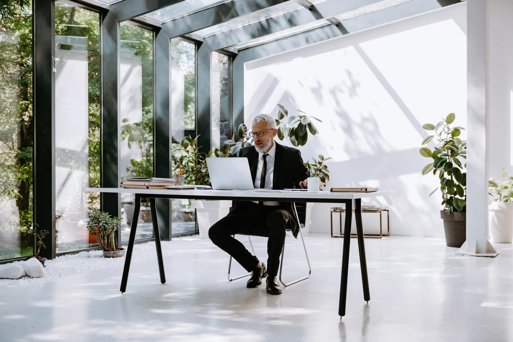 A lawyer working alone through research at a desk in a glass atrium