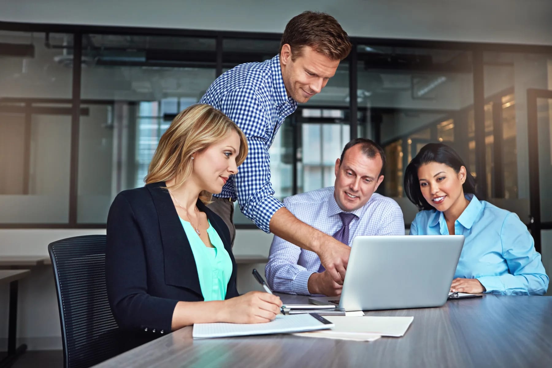 A deal team working through a response together on one laptop