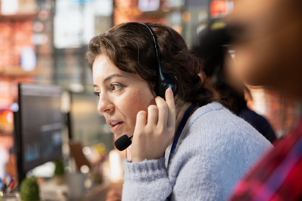A customer support agent wearing a headset while working at her desk